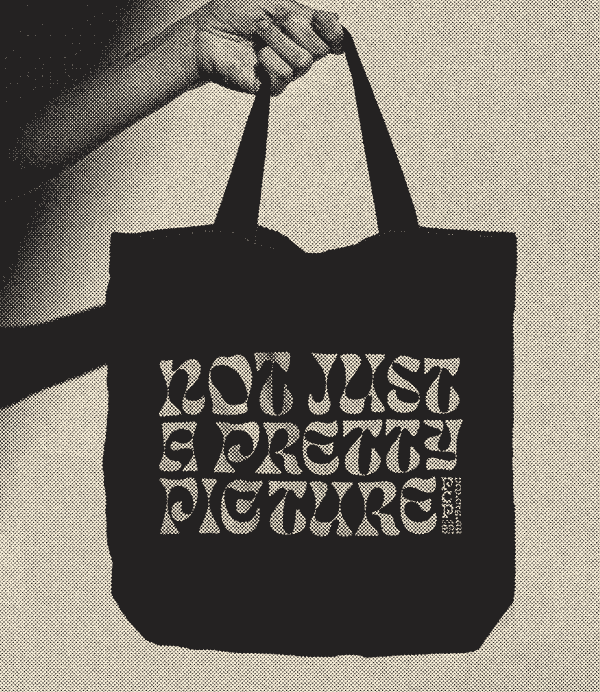 A tote bag with the works 'Not just a pretty picture' printed on it.